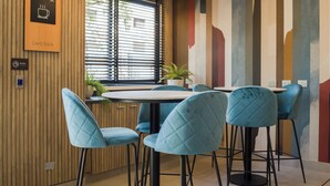 Ein modernes Café mit einer Holzvertäfelung, einem Schild für Kaffeeservice und einem Fenster mit Jalousien.