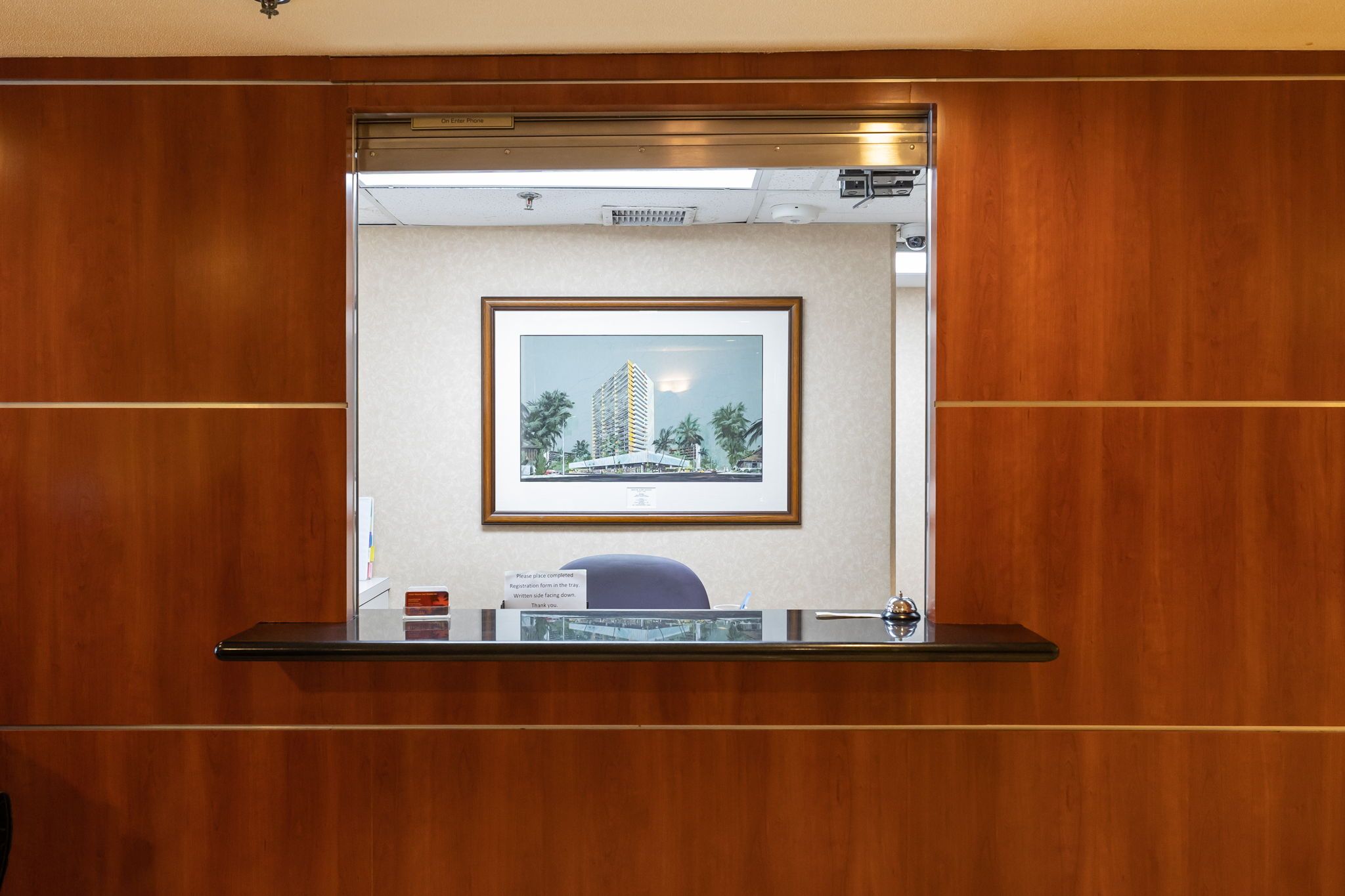 A reception desk with a framed cityscape picture above it.