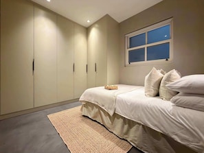 Ein Schlafzimmer mit Bett, Fenster und Kleiderschrank.
