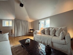 Ein modernes Wohnzimmer mit einer Couch, einem Couchtisch und einer Lampe.