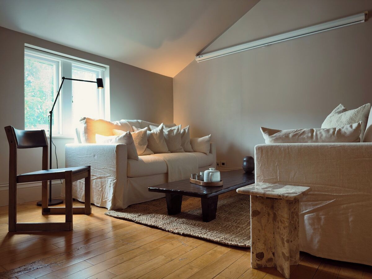 A living room with a sofa, a chair, a coffee table, and a lamp.