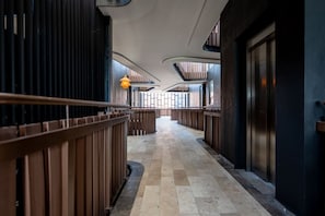 A corridor with a checkered floor, wooden railings, and a curved ceiling. - Luxury 2 BR PH w/Private Pool, Walk to Beach (Tulum)