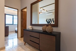 A modern bathroom with a large mirror, a dark wooden vanity, and a towel dispenser. - Luxury 2 BR PH w/Private Pool, Walk to Beach (Tulum)