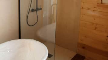 Een moderne badkamer met een douchecabine van glas, een vrijstaand bad en houten lambrisering.