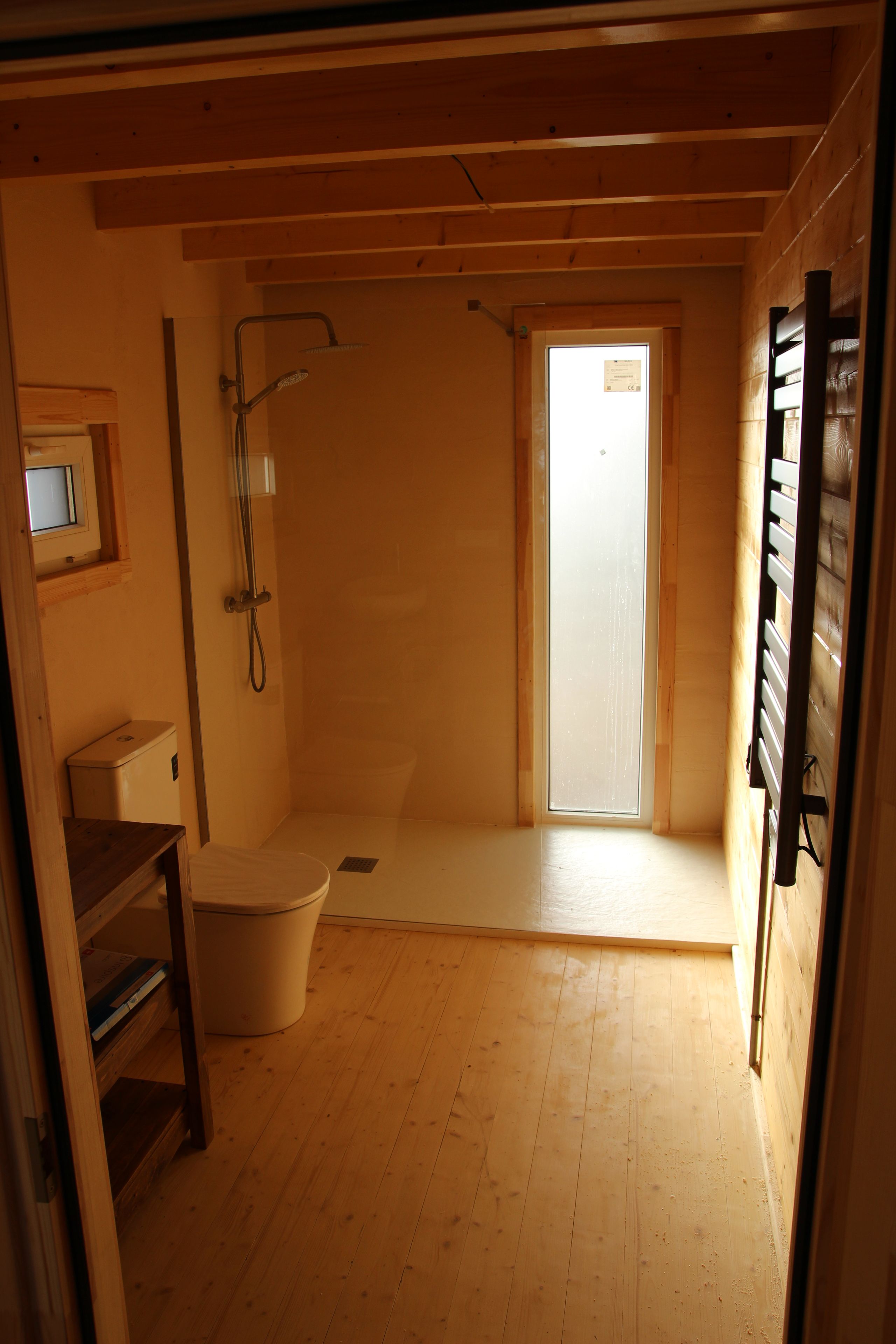 Een kleine badkamer met één ruimte, voorzien van toilet, douche en een raam.