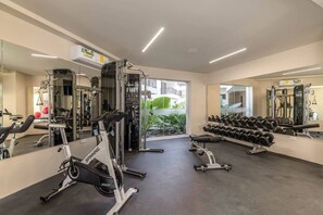 A gym with cardio machines, free weights, and a mirror. - Relaxing 2BR Oasis w/ Pool & Balcony | Sleeps 6 (Tulum)