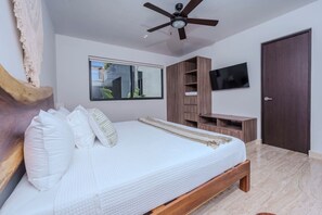 A bedroom with a bed, a ceiling fan, a TV, and a wardrobe. - Relaxing 2BR Oasis w/ Pool & Balcony | Sleeps 6 (Tulum)