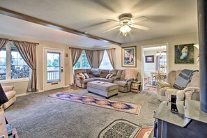 A spacious living room with a large sectional sofa, a fireplace, and a ceiling fan. - Coos Bay Farmhouse Near Ocean, Pet-Friendly (Coos Bay)