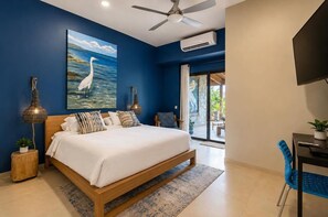 A bedroom with a bed, a ceiling fan, an air conditioning unit, a painting of a bird, and a view of the outdoors. - Villa Koï - 4 bedrooms - pool - Terres Basses (terres basses)