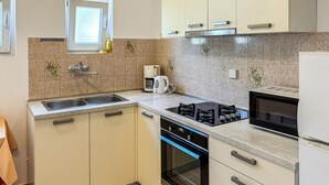 A modern kitchen with a double sink, a coffee maker, a microwave, and a built-in oven. - 3 bedroom gorgeous apartment in Lopar (Lopar)
