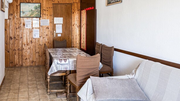 A dining area with a wooden table and chairs, a tiled floor, and a white wall with papers and a framed picture. - 3 bedroom gorgeous apartment in Lopar (Lopar)