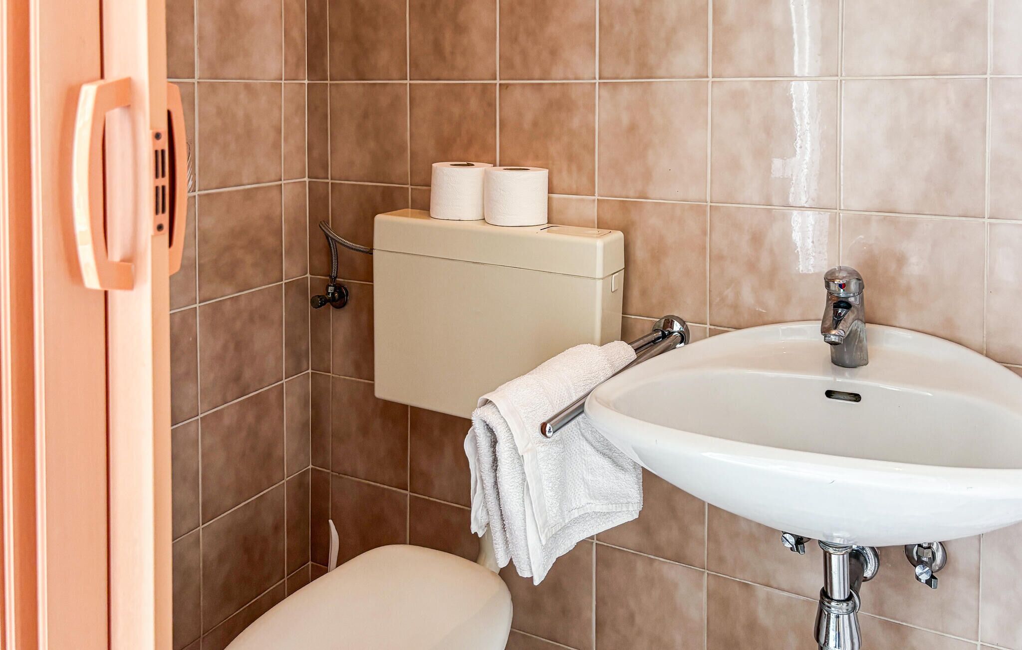 A bathroom with a toilet, a sink, and a shower.