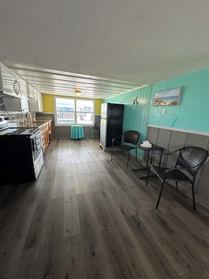 A kitchen with a refrigerator, stove, and wooden cabinets. There is a window with a view of the outside. - Waterfront 2 Bed 2 Bath home, Boat Lift, Trailer Parking, 2 Kayaks and 2 Bikes (Saint James City)