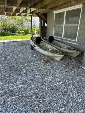 Two kayaks parked on a gravel surface under a wooden structure. - Waterfront 2 Bed 2 Bath home, Boat Lift, Trailer Parking, 2 Kayaks and 2 Bikes (Saint James City)