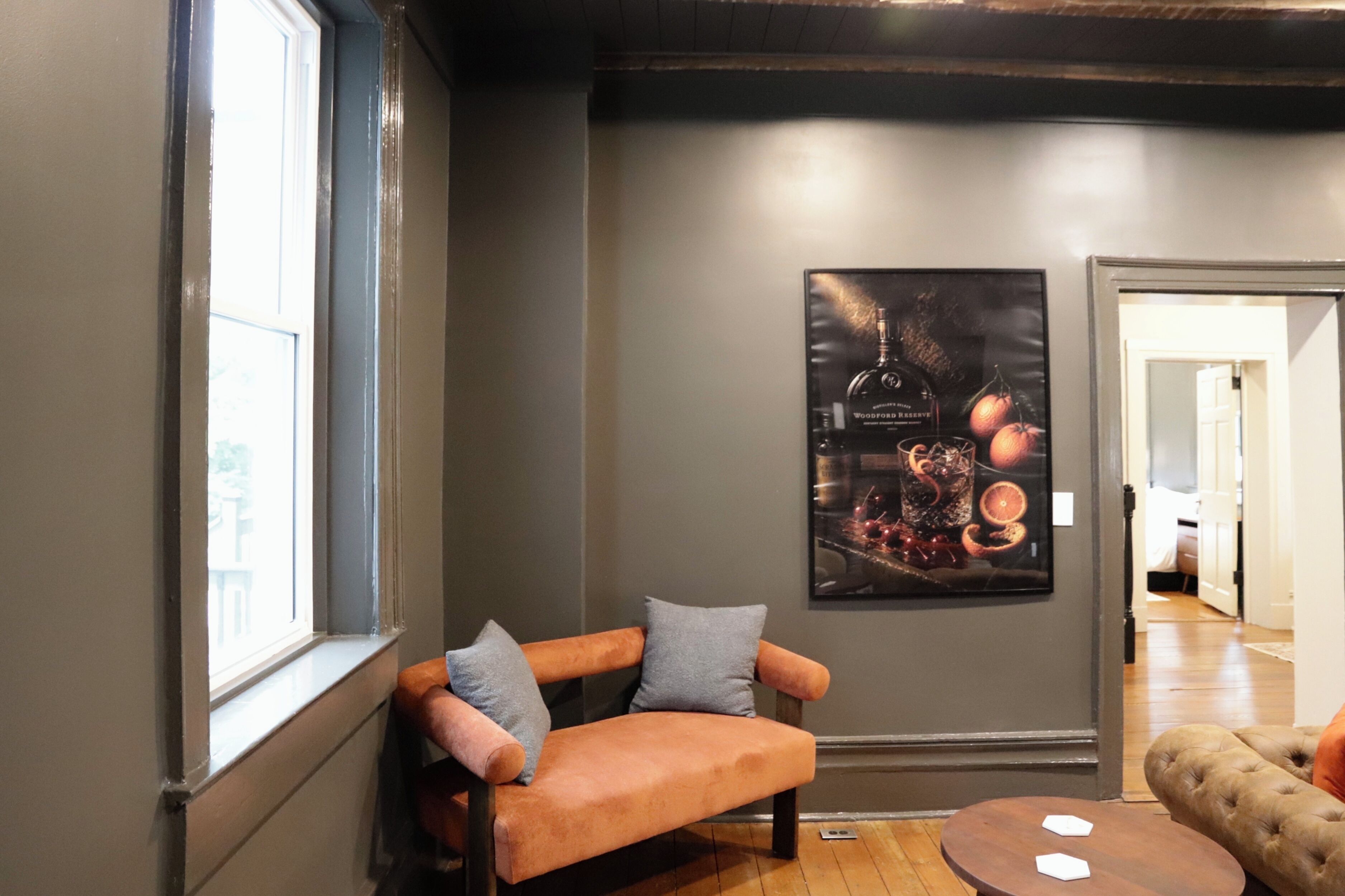 A room with a wooden bench, a round table, and a poster on the wall.