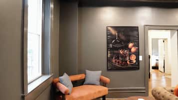 A room with a wooden bench, a round table, and a poster on the wall.