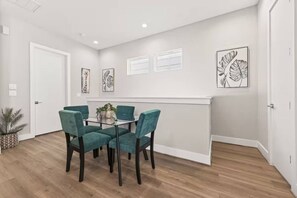 A dining area with a table and chairs, a potted plant, and artwork on the walls. - Cozy Northside home ~20 mins to downtown Houston (Houston)