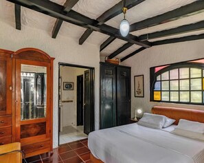 Une chambre à coucher avec un lit, une armoire en bois et une fenêtre donnant sur un beau paysage.