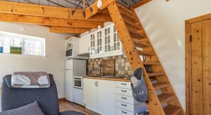 A compact kitchen with white cabinets, a built-in oven, and a wooden staircase. - Holiday home on the beautiful island of Aspö (Drottningskär)