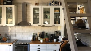 A kitchen with white cabinets, a stove, and various kitchen items.