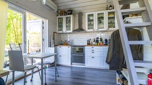 A kitchen with white cabinets, a stove, and a dining area with a table and chairs.