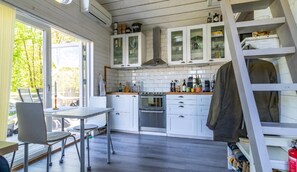 A kitchen with white cabinets, a stove, and a dining area with a table and chairs.