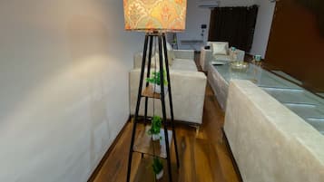 A modern living room with a standing floor lamp, a sofa, a coffee table, and a small plant.