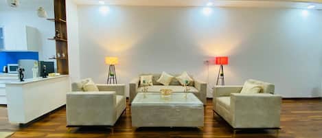 A modern living room with a wooden ceiling, two sofas, a coffee table, and two floor lamps.