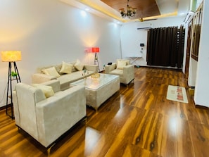 Una sala de estar moderna con un conjunto de sofás, una mesita de centro y una lámpara de pie.