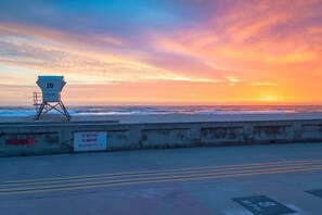 A lifeguard tower with a sign indicating no alcohol, no smoking, and no glass bottles. - Beach Break by Coastline Vacation Rentals (San Diego)