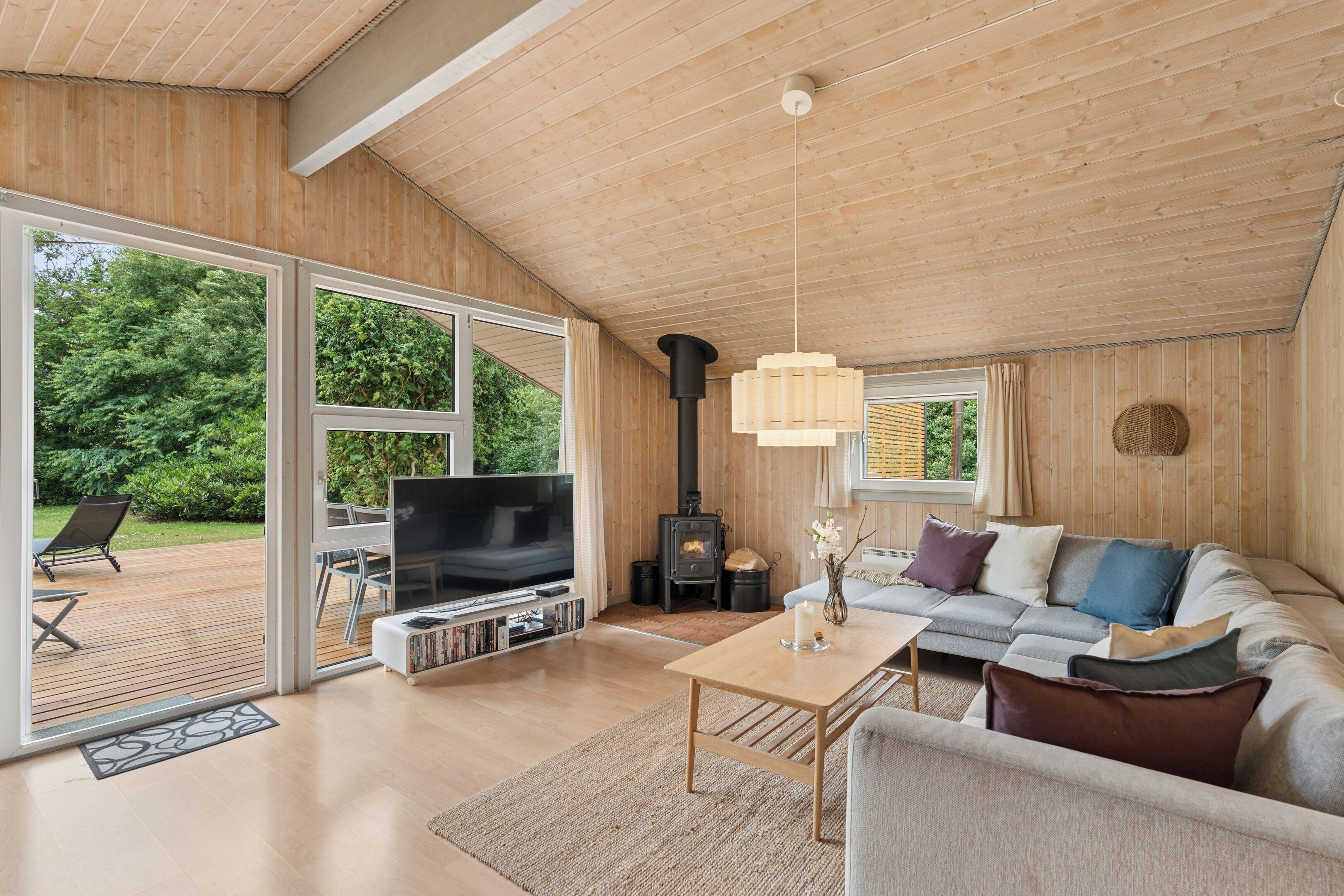 Una sala de estar moderna con televisor, sofá y chimenea.