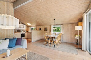Ein gemütliches Interieur mit Essbereich, Küche und Wohnbereich mit Sofa und Tisch.