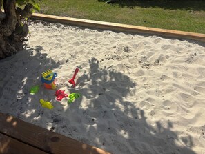 A sandbox with toys and a wooden border. - Holiday Home in Jegum Ferieland (Oksbøl)
