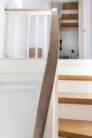 A staircase with white walls and wooden steps. - Townhouse in the heart of the City of Roses (Mariager)