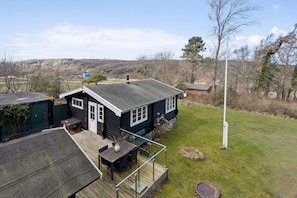 A cabin with a deck, a small table, and a chair. - Authentic holiday home with Baltic Sea view (Allinge-Sandvig)