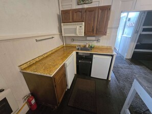A compact kitchen with a microwave, sink, and dishwasher. - Bunkhouse - Budget Crash Pad - East Carson Street (Pittsburgh)