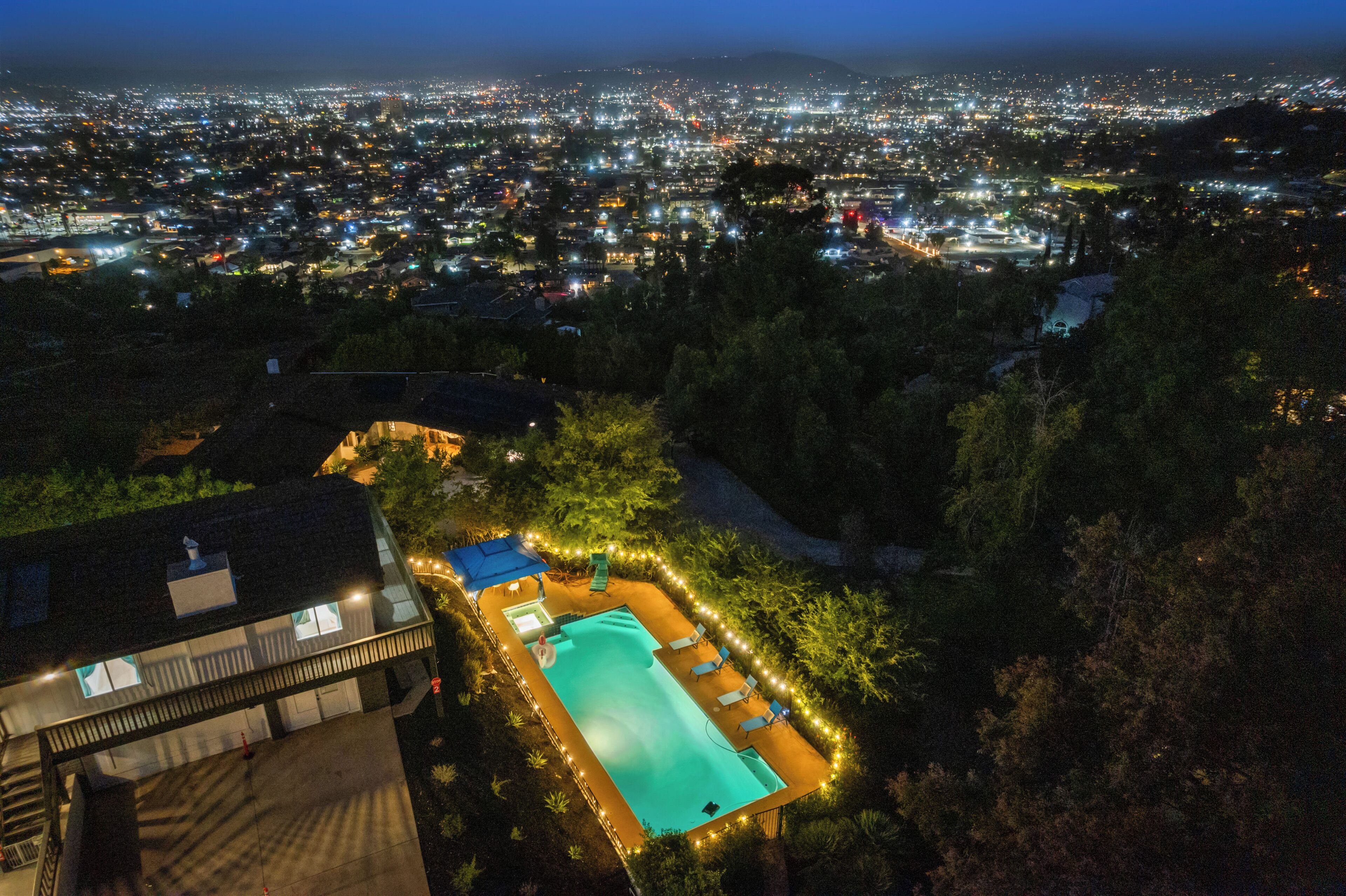 A residential area with a swimming pool surrounded by trees and a building with a balcony.