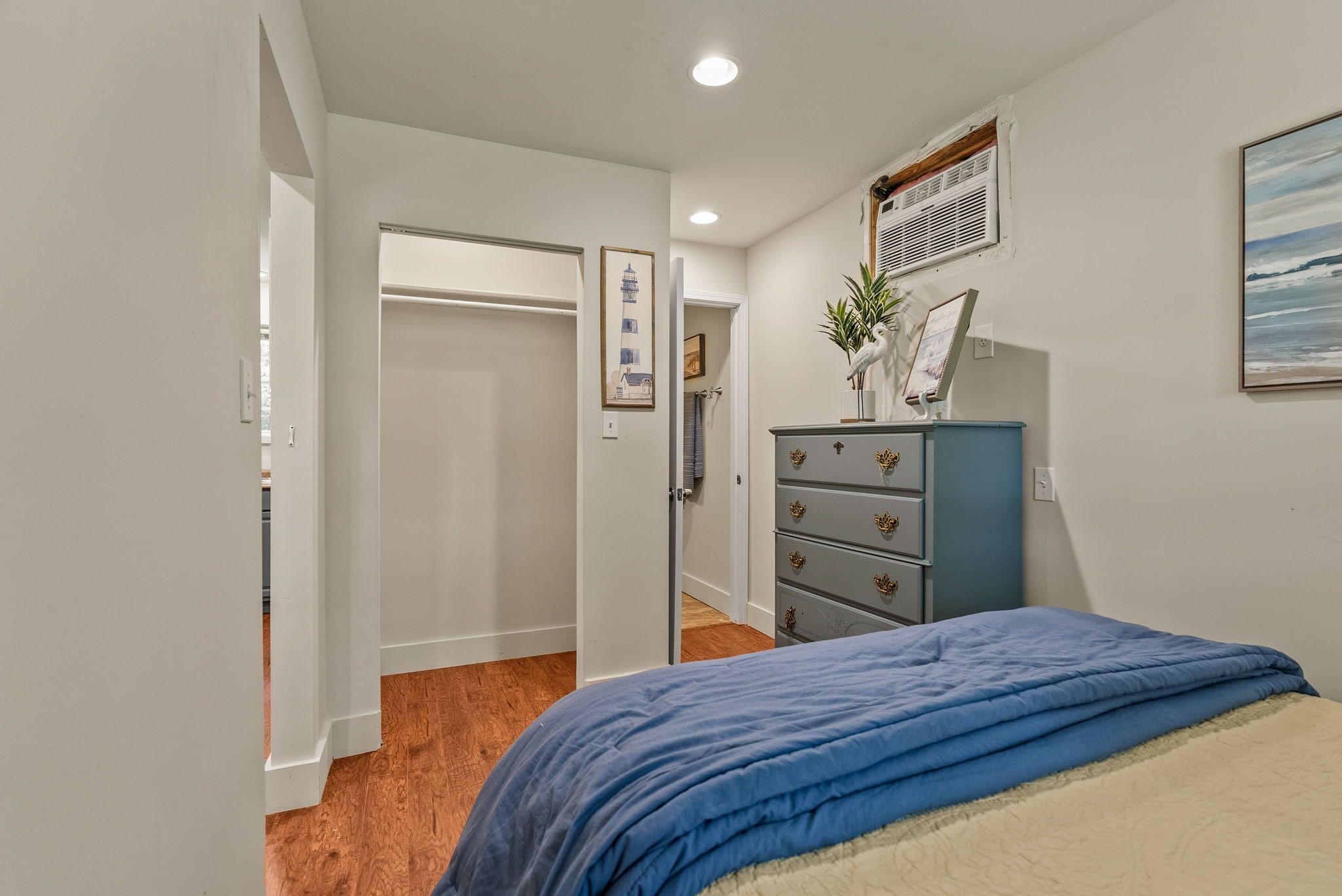Un dormitorio con cama, cómoda y puerta que da a otra habitación.