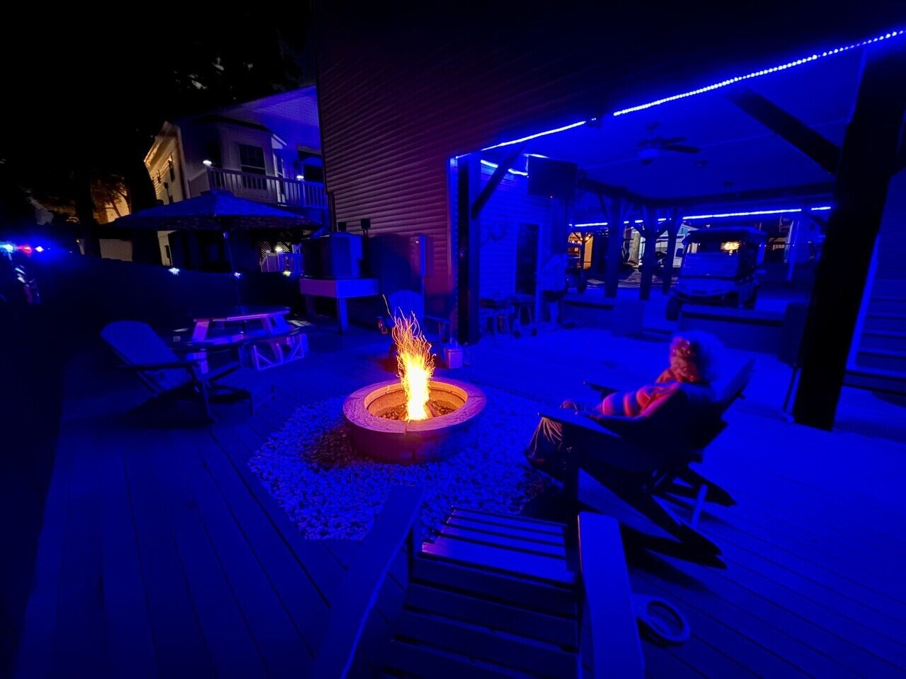 An outdoor patio area with a fire pit, seating, and ambient lighting.