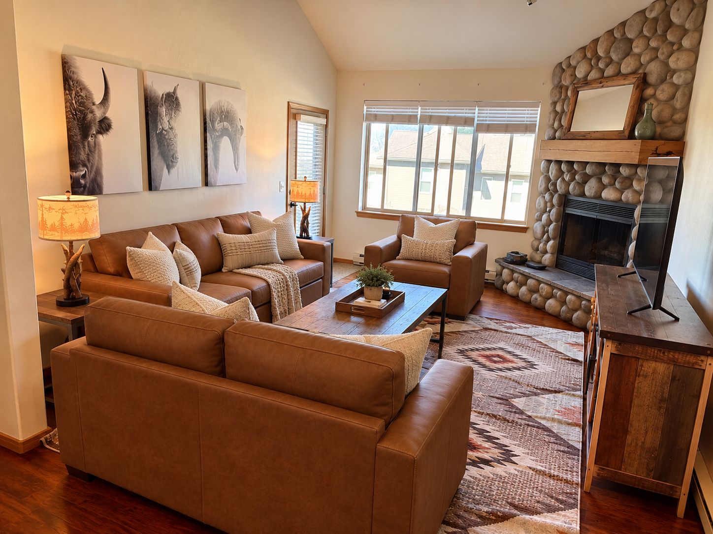 A living room with leather sofas, a fireplace, and artwork on the wall.