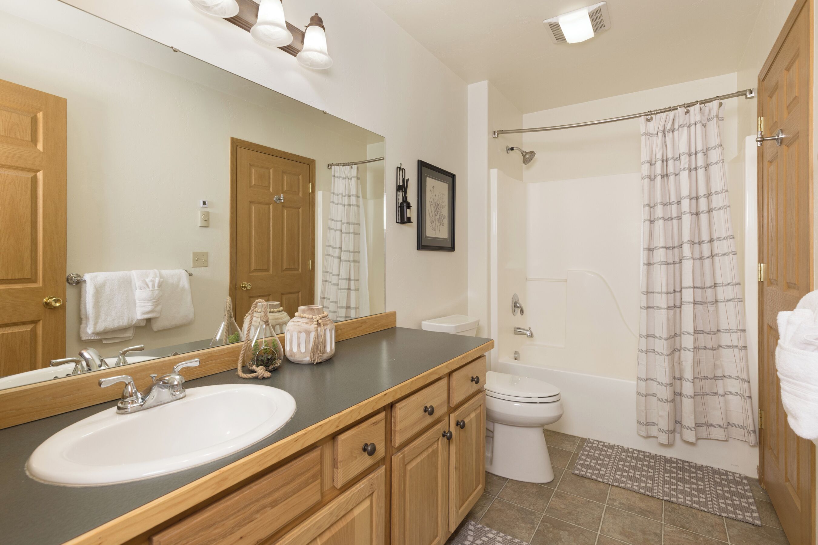 A bathroom with a sink, toilet, and shower.