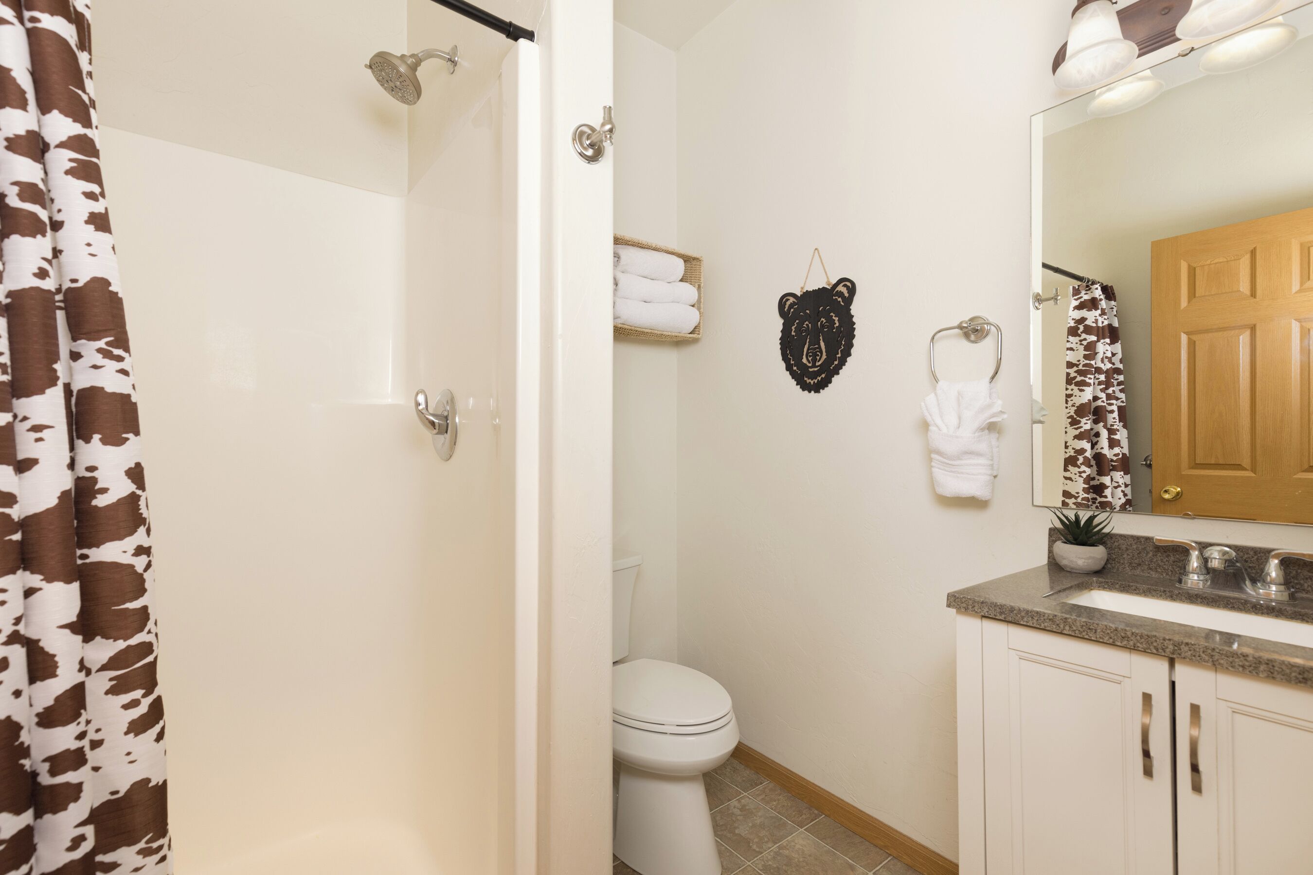 A bathroom with a shower, toilet, and sink.
