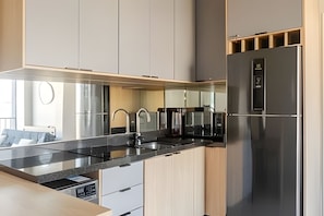 Uma cozinha moderna com eletrodomésticos de aço inoxidável, forno embutido e lava-louças.