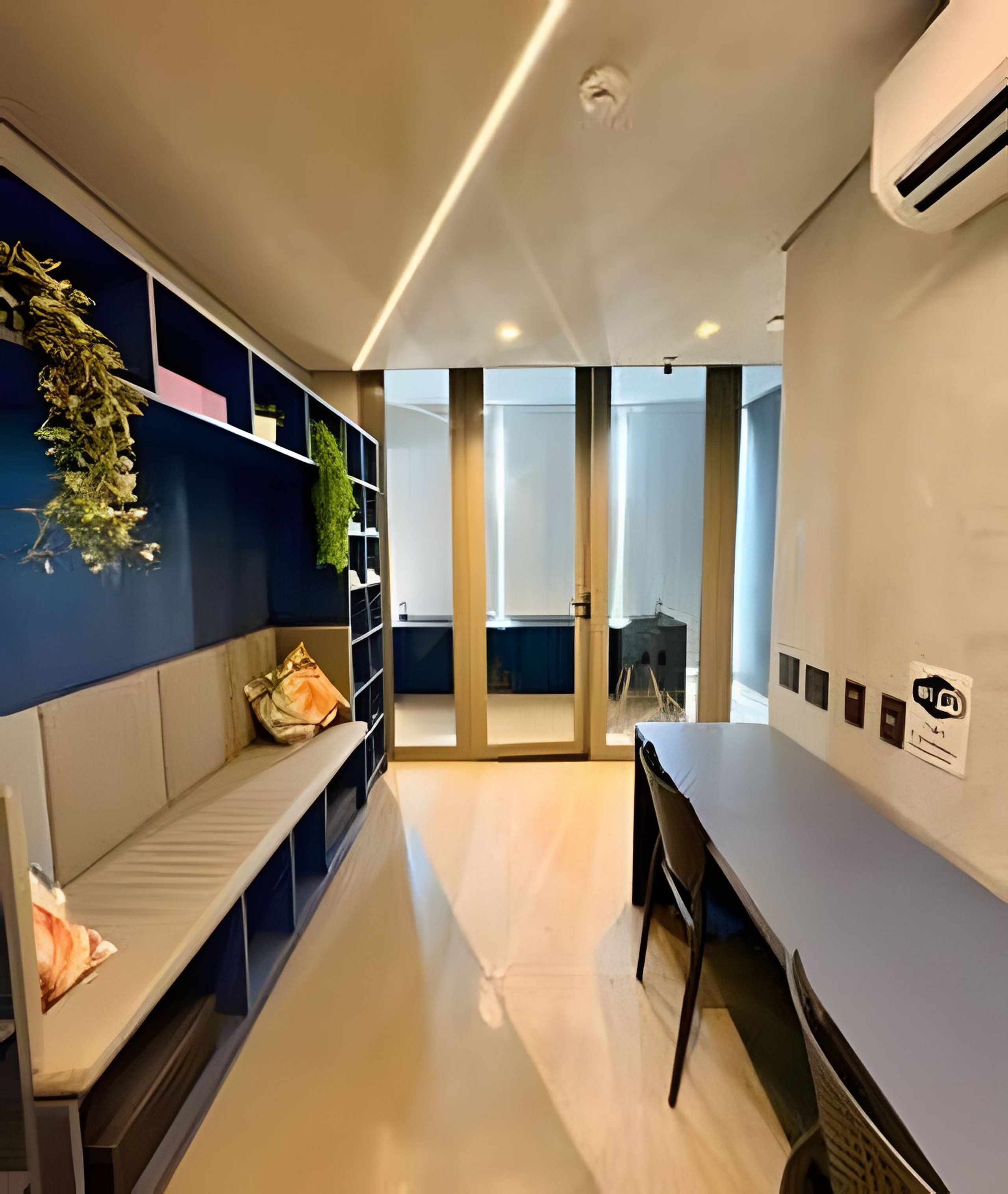 A modern hotel room with a seating area, a desk, and a view of the outdoors.
