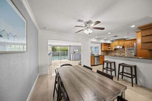 A modern kitchen with wooden cabinets, a central island, and a ceiling fan. - 2600 Managed by Brampton Park (Pompano Beach)
