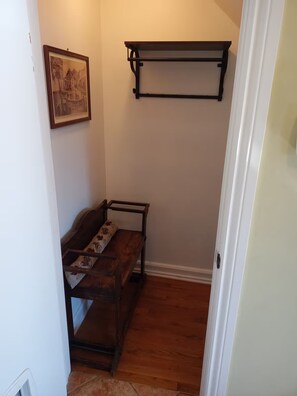 A hallway with a wooden bench, a wall-mounted shelf, and a framed picture. - Cozy 2 bedroom close to downtown, public transportation & airport (Montréal)