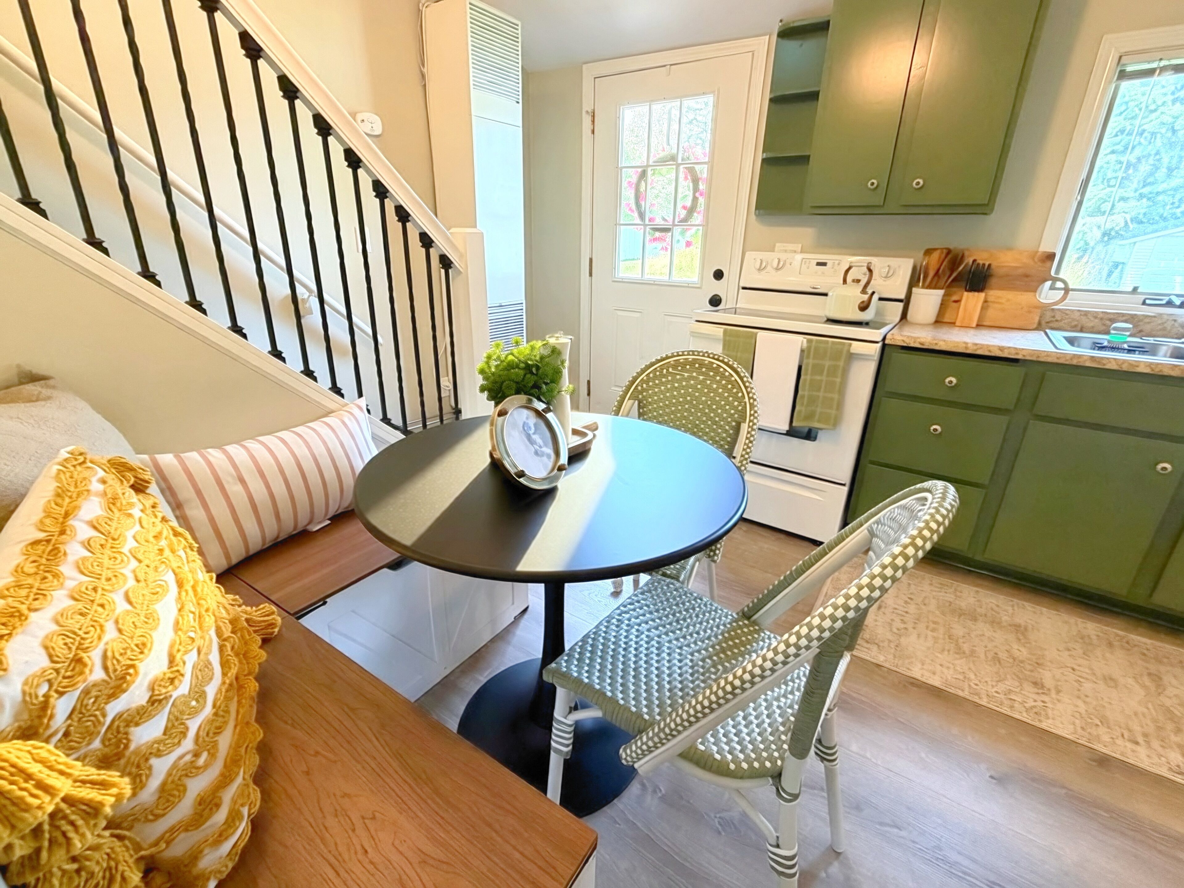 Cocina acogedora con comedor, que incluye una escalera, un reloj y una ventana con vistas.