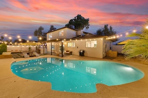 A swimming pool with a house in the background, string lights, and outdoor furniture. - NEW • 5BR • Heated Pool • Golf • Fire Pit • Games (Glendale)