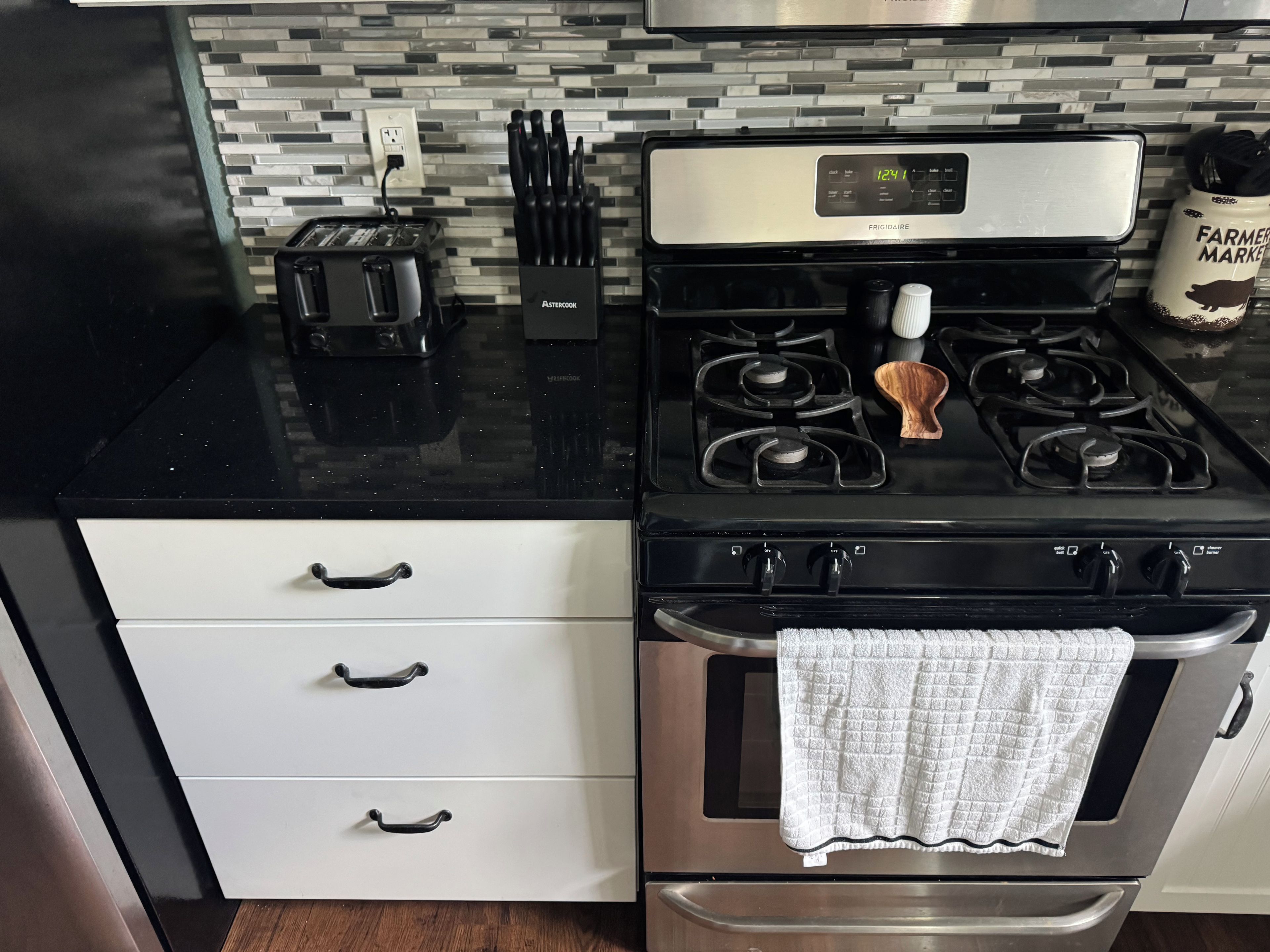 A kitchen with a stainless steel stove, a toaster, and a knife block.