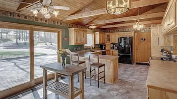 Une cuisine spacieuse avec des meubles en bois, un îlot central et un coin repas avec des chaises.